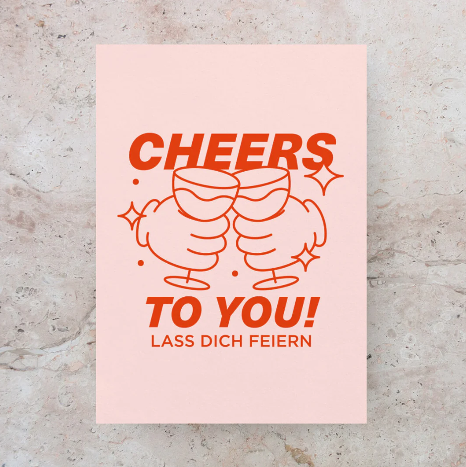 Postkarte DIN A6 mit Schriftzug „Cheers to you“ in roter Typografie auf rosafarbenem Karton, Design von Studio Ciao