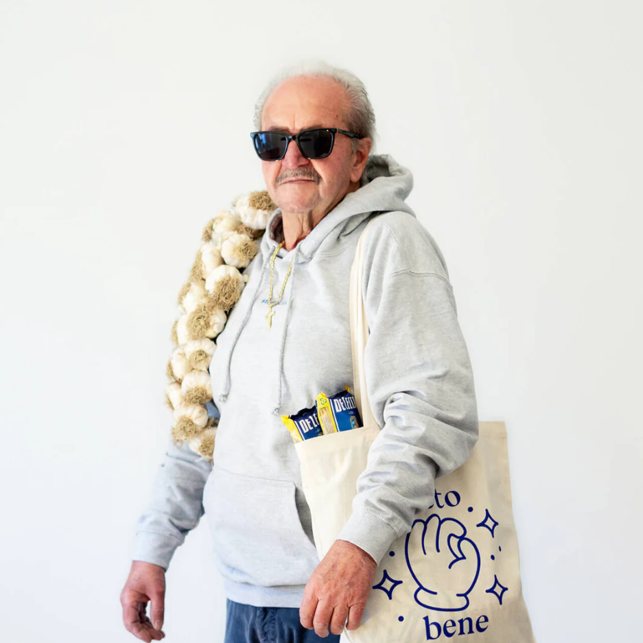 Naturfarbener Jutebeutel mit blauem Schriftzug "tutto bene" und langen Henkeln, getragen von einem Mann, Design von Studio Ciao